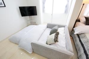 a white couch in a room with a tv at Green Gables B棟 108 in Toyama