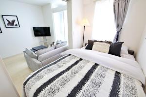 a bedroom with a bed and a couch and a television at Green Gables B棟 108 in Toyama +34 photos