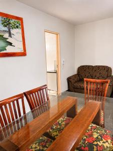 a dining room with a table and chairs and a couch at Apartamento Residencial Alice in Uberaba