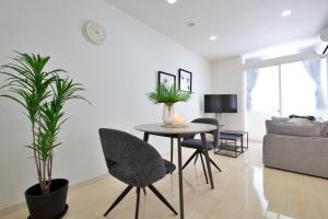 a living room with a table and chairs and a couch at Green Gables B棟 108 in Toyama