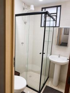 a bathroom with a shower and a toilet and a sink at Apartamento Residencial Alice in Uberaba