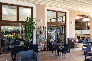 a restaurant with tables and chairs and windows at Hotel La Quercia in Valmontone