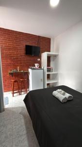 a bedroom with a black bed and a kitchen with a table at Apartamentos Villa Jardin in Reyes