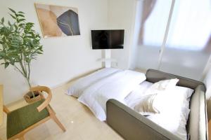 a bedroom with a bed and a tv on a wall at Green Gables A棟 105 in Toyama