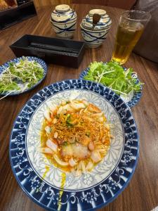 a table with a plate of food and a glass of beer at Đại Thắng Hotel in Danang