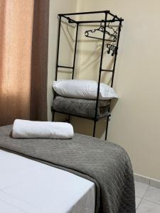 a room with two chairs and a bed with a pillow at Saif Economy Apart in Paranaguá +4 photos