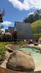 a house with a large rock in front of it at Cabana dos Colibris in Santa Teresa