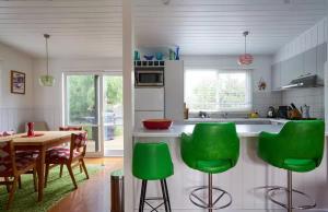 a kitchen with a table and some green chairs at Clambake Beach House in Cape Woolamai