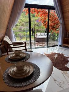 a living room with a table with dishes on it at Cabana dos Colibris in Santa Teresa