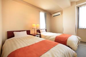 
Tempat tidur dalam kamar di Fujinomiya Green Hotel
