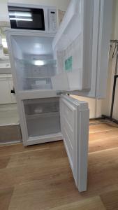 an empty refrigerator with its door open in a kitchen at 奄美ザナゼステイTheNazeStay in Amami