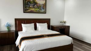 a bedroom with a large bed with white sheets at Văn Lâm Hotel in Ðình Dù