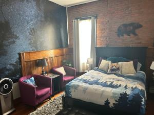a bedroom with a bed and two chairs at Aspen Inn in Creede +21 photos