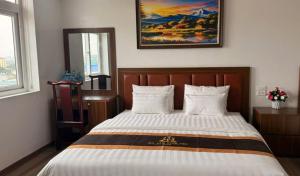a bedroom with a bed with a picture on the wall at Văn Lâm Hotel in Ðình Dù +7 photos