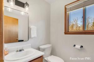 a bathroom with a toilet and a sink and a mirror at Cabin in Wellston in Wellston