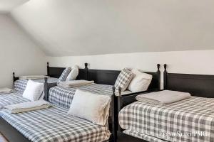 four beds in a room with checkered sheets at Cabin in Wellston in Wellston