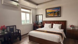 a bedroom with a bed and a painting on the wall at Văn Lâm Hotel in Ðình Dù
