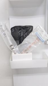 a white drawer with two toothbrushes and a black bag at 奄美ザナゼステイTheNazeStay in Amami