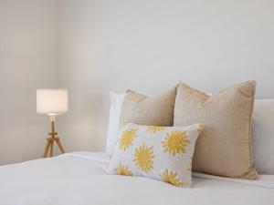 a bedroom with a bed with pillows and a lamp at Oasis By Khove - Broadbeach Waters in Gold Coast