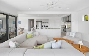 a living room with a white couch and a kitchen at Oasis By Khove - Broadbeach Waters in Gold Coast