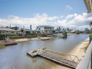 a boat on a river with buildings in the background at Oasis By Khove - Broadbeach Waters in Gold Coast +26 photos