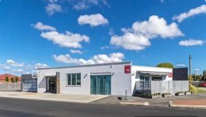 a white building on the side of a road at Ruby SoHo Workshop Villa in Port Sorell