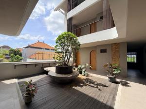 a balcony with a tree sitting on top of a building at Kalpa Tree Co-living in Canggu