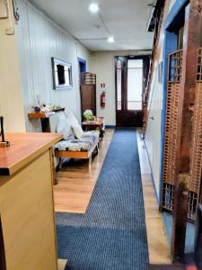 a hallway with a living room with a rug at Hostal Punto Austral in Puerto Montt