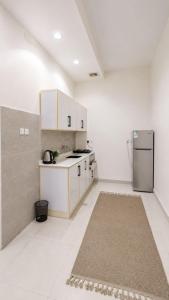 a kitchen with white cabinets and a refrigerator at وحدات سكنية الشفا in Khamis Mushayt