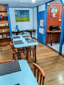a room with a table and chairs and a kitchen at Hostal Punto Austral in Puerto Montt