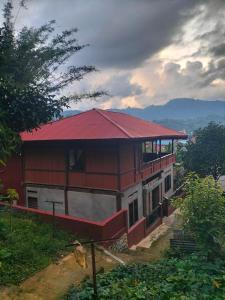 a red house with a red roof on a hill at Pong Elak 'Guest House in Rantepao