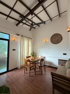 a living room with a wooden table and chairs at Earthora Escape in Dickwella