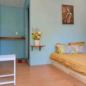 a room with a couch and a vase with flowers on a shelf at BONNIE HOMESTAY Mui Ne in Mui Ne