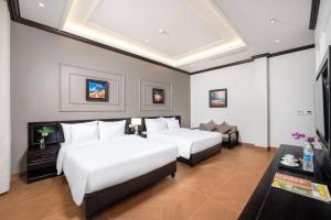a hotel room with two beds and a couch at Aluna Tam Coc Hotel in Ninh Binh