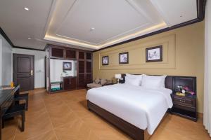 a bedroom with a large white bed and a piano at Aluna Tam Coc Hotel in Ninh Binh
