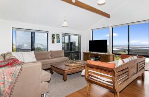 a living room with a couch and a tv at Ocean Blue View in Capel