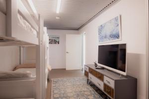 a bedroom with a bunk bed and a flat screen tv at Ruby SoHo Workshop Villa in Port Sorell