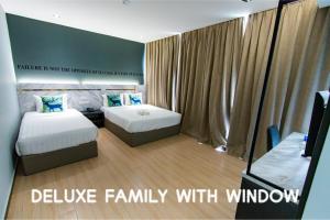 a room with two beds and a television in it at Hotel 99 Sepang KLIA & KLIA2 in Sepang +32 photos