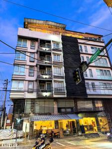 a tall building with motorcycles parked in front of it at The Upperhouse Hotel Boutique Stay with City & River Views in Cagayan de Oro