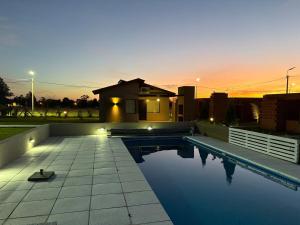 a swimming pool in front of a house at Don Miguel in Balcarce