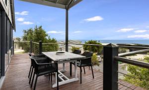 a patio with a table and chairs on a balcony at Ocean Blue View in Capel