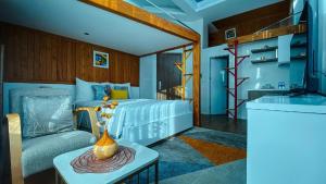 a bedroom with a bed and a couch and a table at Hanoi Amsterdam Art Studio in Da Lat