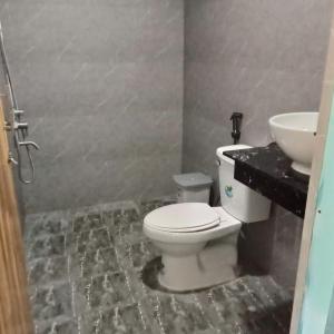 a bathroom with a toilet and a sink at BONNIE HOMESTAY Mui Ne in Mui Ne