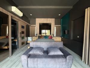 a bedroom with a large bed and a couch at Huather villa & cafe หัวเท่อวิลล่า in Ban Hin Sam Kon