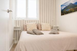 a white bed with pillows on it in a room at Hondarribia con Piscinas, Terraza Privada, Parking y Tenis - CASA OLABIDE in Hondarribia +20 photos