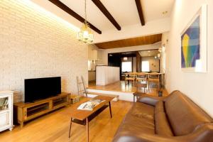 a living room with a couch and a tv at お宿 想-Oyado Sou- in Asakura