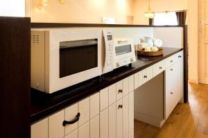 a kitchen with a counter with a microwave and a sink at お宿 想-Oyado Sou- in Asakura