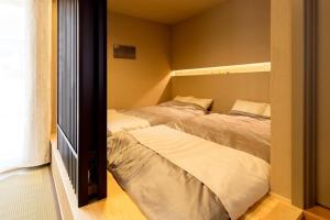 a bedroom with two beds and a window at お宿 想-Oyado Sou- in Asakura