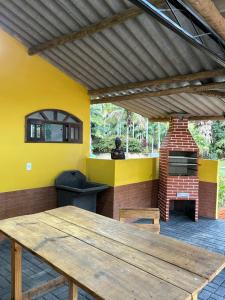 a patio with a wooden table and a brick oven at Catavento in Paty do Alferes