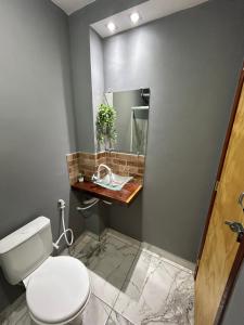 a bathroom with a white toilet and a mirror at Catavento in Paty do Alferes +7 photos